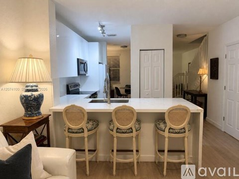 A dining room with a white table and chairs.