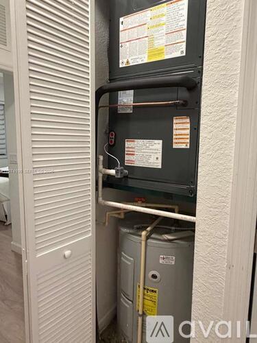 A wall-mounted electrical panel with various wires and a yellow caution label.