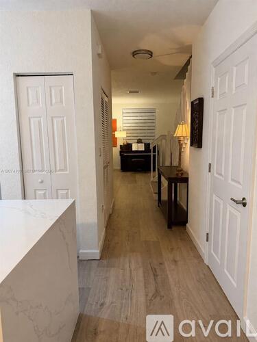 A hallway with white doors and a wooden floor.