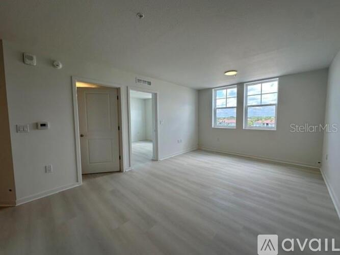 A spacious room with a window and a door.