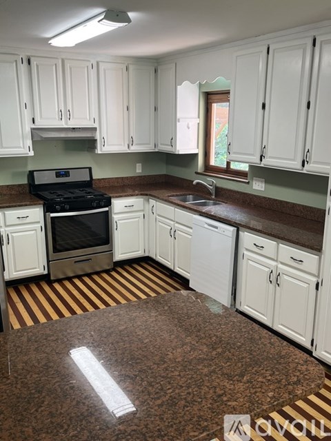 A kitchen with white cabinets and a black stove top oven.