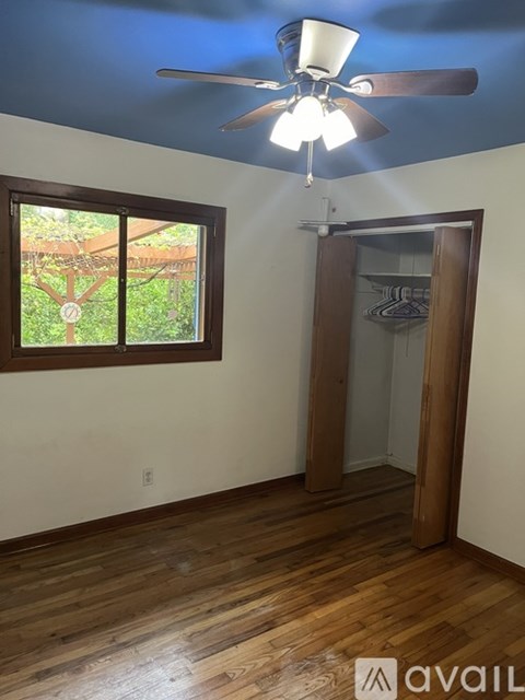 A room with a ceiling fan and a window.