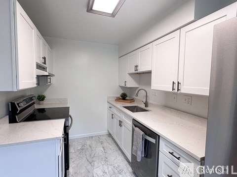 A kitchen with white cabinets and a black stove top oven.