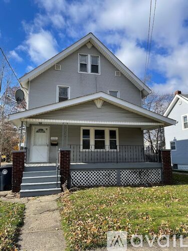 A two-story house with a front porch and a white door.
