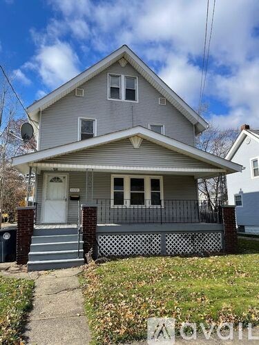 A two-story house with a front porch and a white door.