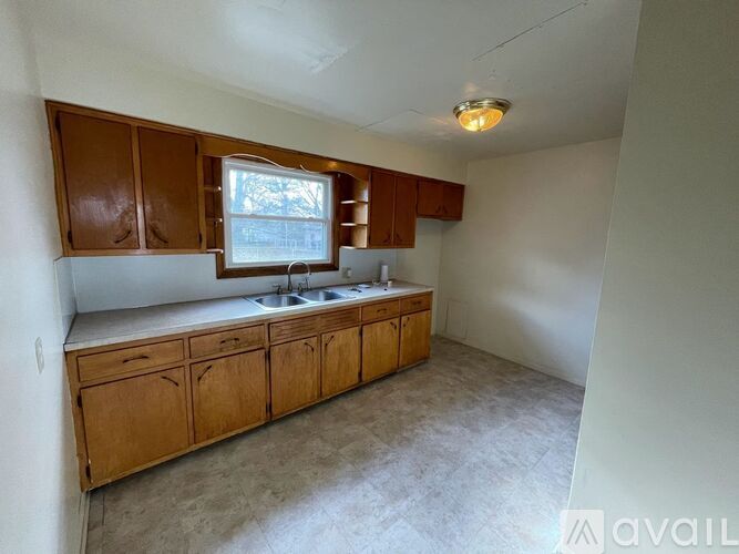 A kitchen with wooden cabinets and a window.