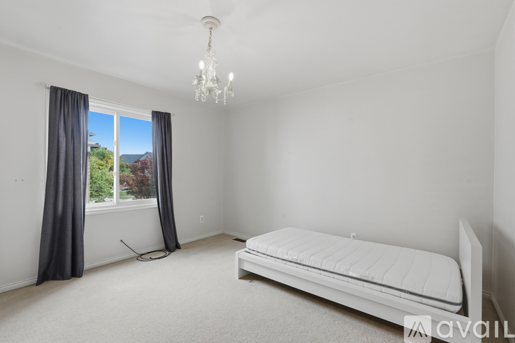 A bedroom with a large bed and a chandelier.