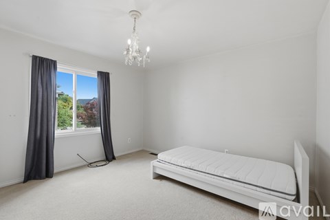 A bedroom with a large bed and a chandelier.