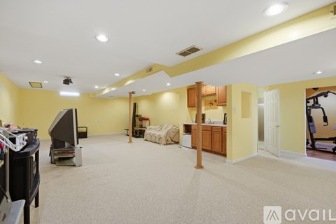 A spacious room with a television, exercise equipment, and a large window.