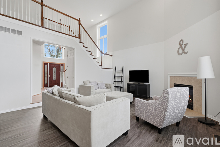 A living room with a white couch and a fireplace.