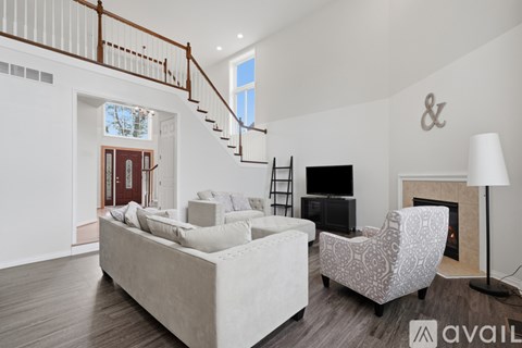A living room with a white couch and a fireplace.