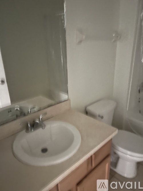 A bathroom with a sink, mirror, and toilet.