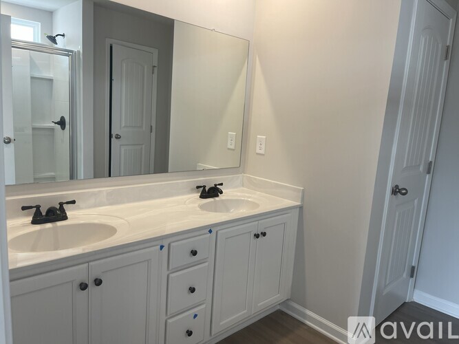 A bathroom with a sink, mirror, and cabinets.