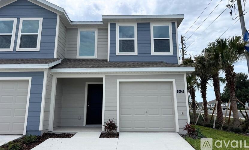 A two-story house with a garage and a driveway.