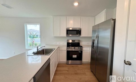 A kitchen with white cabinets and stainless steel appliances.