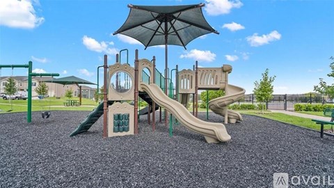 A playground with a green slide and a brown slide under a black umbrella.