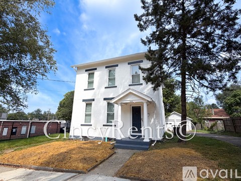 A white house with a black door and windows is for rent.