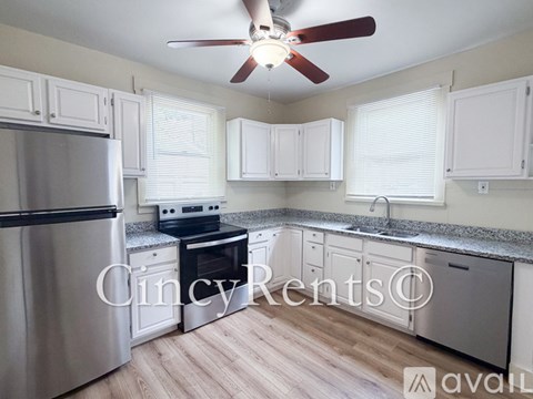 A kitchen with white cabinets and a stainless steel refrigerator.