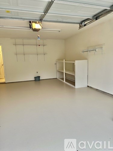 A large empty room with a white floor and a white ceiling with a light hanging from it.
