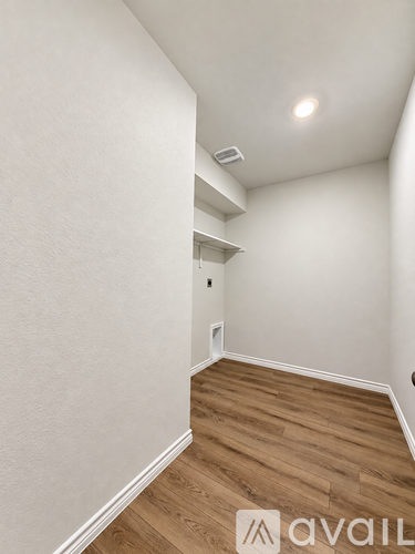 A room with wooden flooring and white walls.