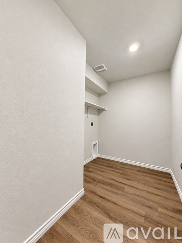 A room with wooden flooring and white walls.