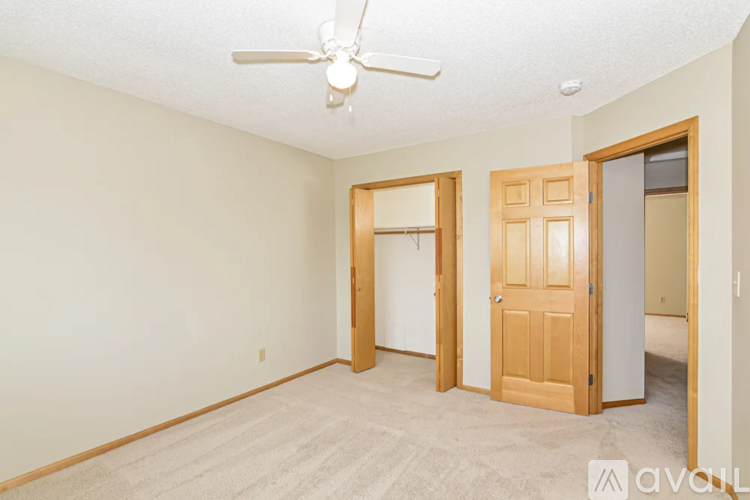 A room with a ceiling fan and two doors.