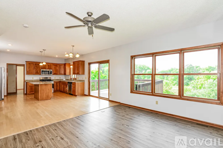 A spacious living room with a ceiling fan and sliding glass doors.