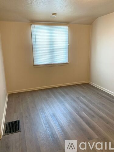 A room with a window and wooden flooring.