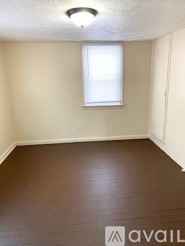 A room with a window and wooden flooring.