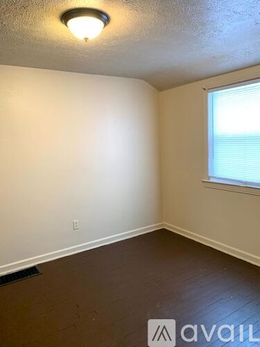 A room with a window and a light on the ceiling.
