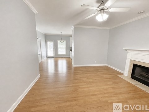 A spacious room with a fireplace and a ceiling fan.