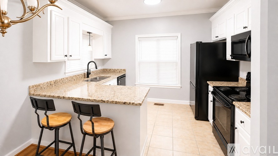 A kitchen with black appliances and white cabinets.