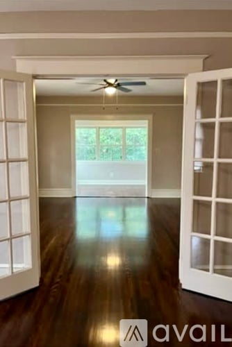 A room with a ceiling fan and wooden floors.