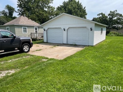 A white garage with a black truck parked in front.