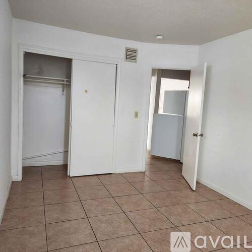 A room with a tiled floor and two doors, one of which is open.