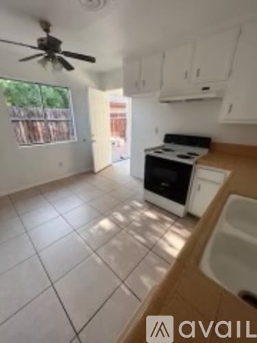 A kitchen with a fan and a stove top oven.