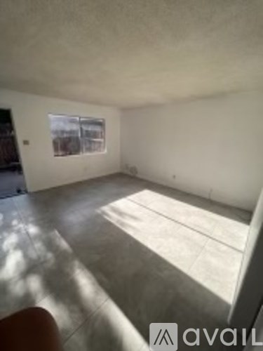 A room with a window and sunlight coming through.