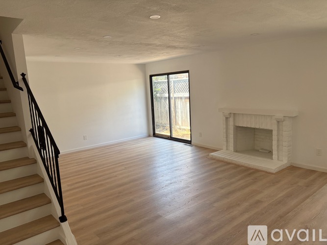 A living room with a fireplace and sliding glass doors.