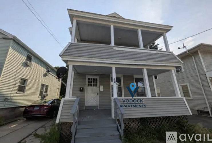 A two-story building with a balcony and a sign that says "YODOCK APARTMENTS" is available for rent.