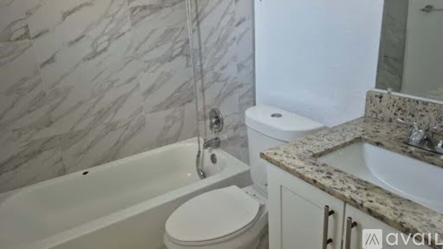 A bathroom with a marble wall and a white toilet.