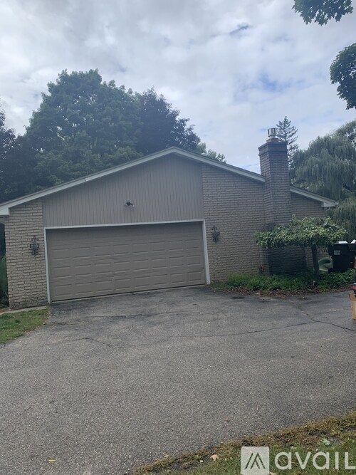 A two-car garage with a chimney is situated in a residential area.