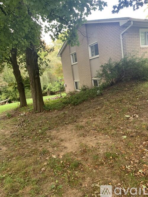 A house with a brown roof and a tree in front of it.