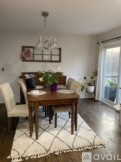 A dining room with a wooden table and chairs.