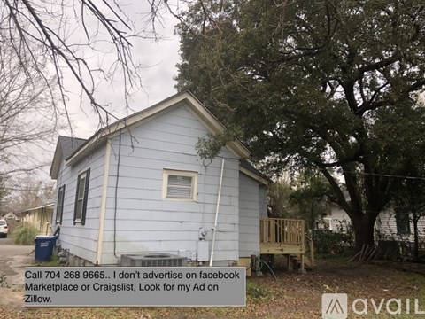 A small blue house with a sign in front of it.