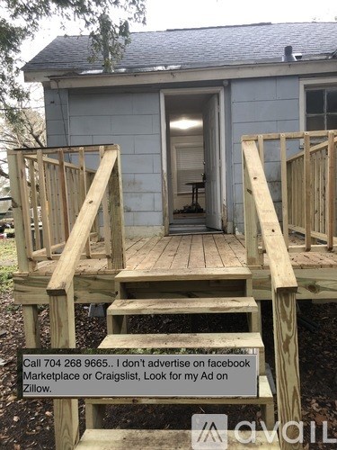 A wooden deck with steps leading to a house entrance.