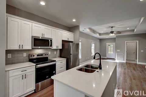 A modern kitchen with white cabinets and stainless steel appliances.