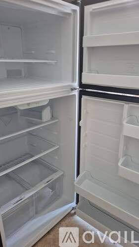 Empty white refrigerator with black handles.