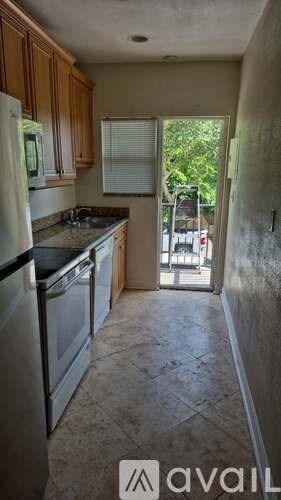 A kitchen with a refrigerator, stove, and sink.