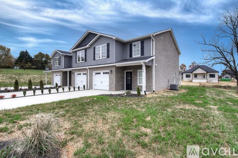 A modern house with a grey exterior and a large front yard.
