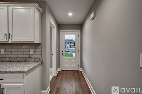 A kitchen with white cabinets and a view of a building outside the window.
